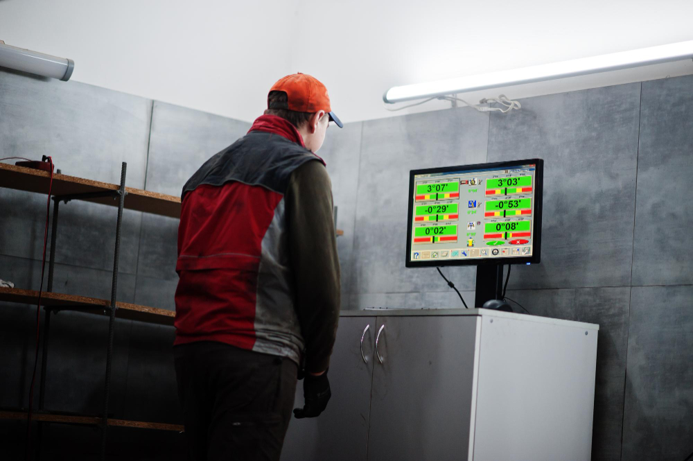 Foto eines Mechanikers, wie dieser vor einem Monitor steht.